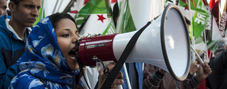 A woman uses a megaphone during a demonstration